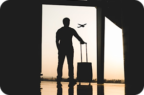 Person with luggage looking at a plane, representing travel insurance