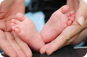 Hands holding feet, representing life insurance